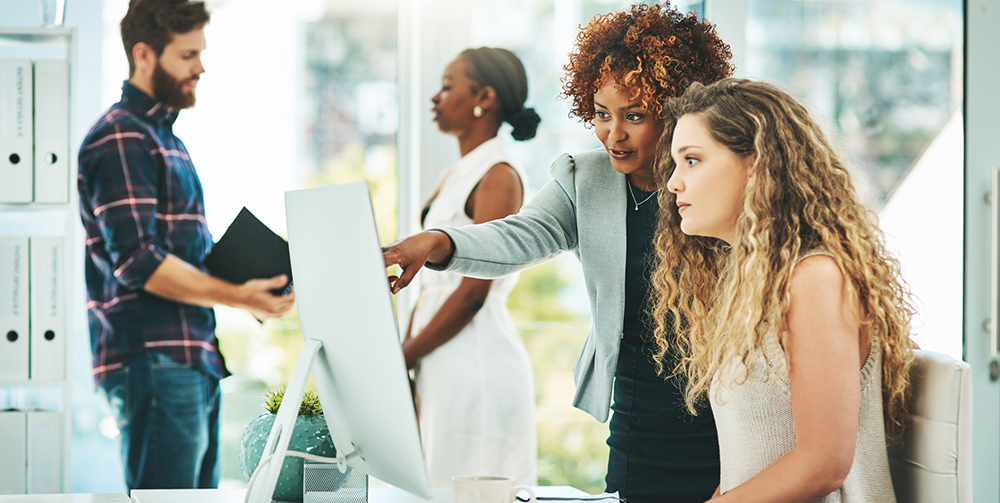 Woman points out something on a screen to coworker