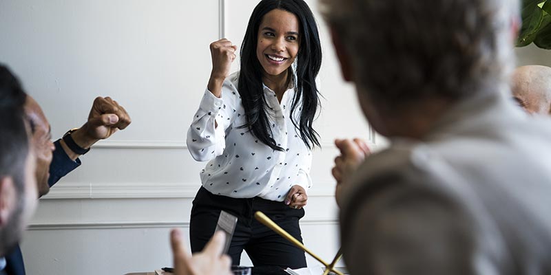 High-potential employee celebrating success by raising a fist with a smile.