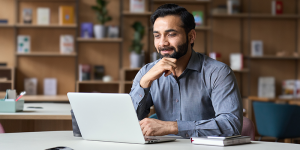 Man sits at a computer ready to design a strong L&D program.