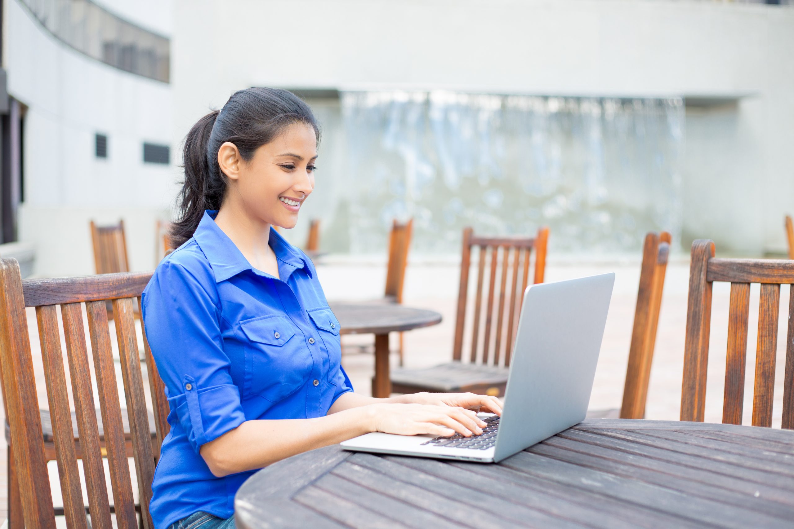 woman using laptop in courtyard